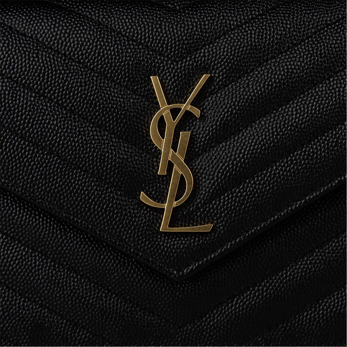 Close-up: black quilted envelope flap with gold YSL monogram logo