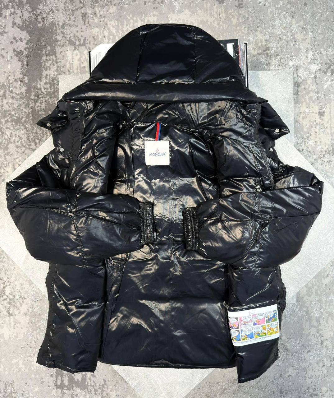 Black puffer jacket with hood and red-trimmed front zipper