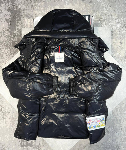 Black puffer jacket with hood and red-trimmed front zipper