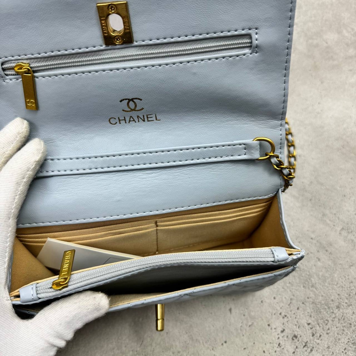 Light blue quilted leather shoulder bag with top flap, gold chain and hardware, interior visible