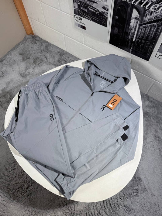 Hooded zip tracksuit jacket in light blue with logo patch and orange tag