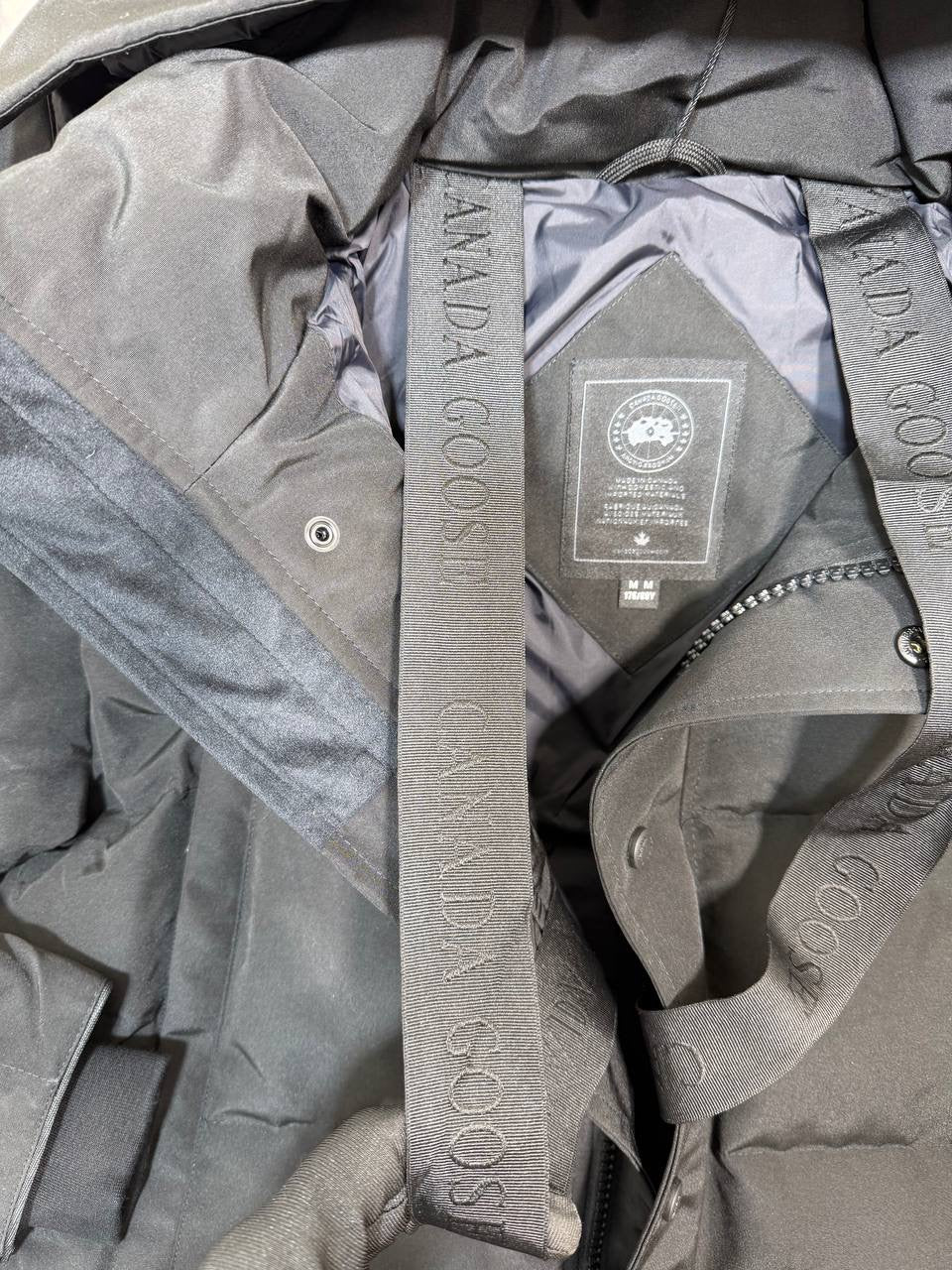 Grey CG coat lining with visible inner tags and zipper at collar