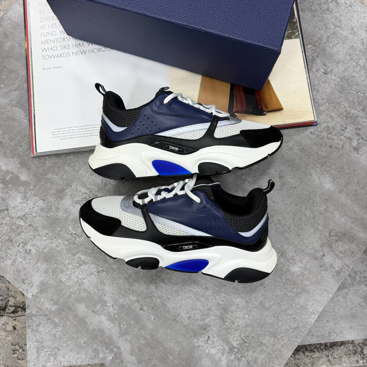 Black and blue low-top trainers with chunky white sole, lace-up and mesh panels