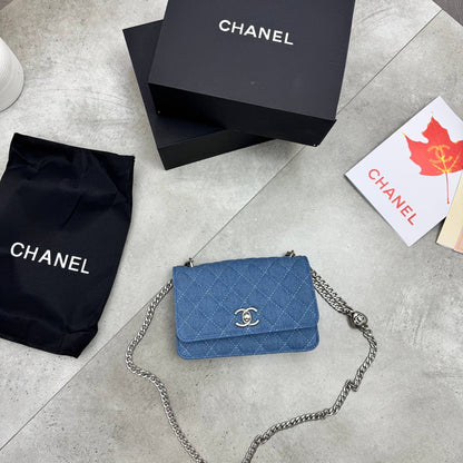 Blue quilted denim flap bag with silver chain strap and front logo clasp