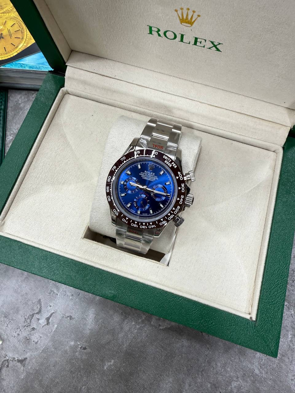 Rolex blue dial chronograph watch with silver bracelet, set in open box