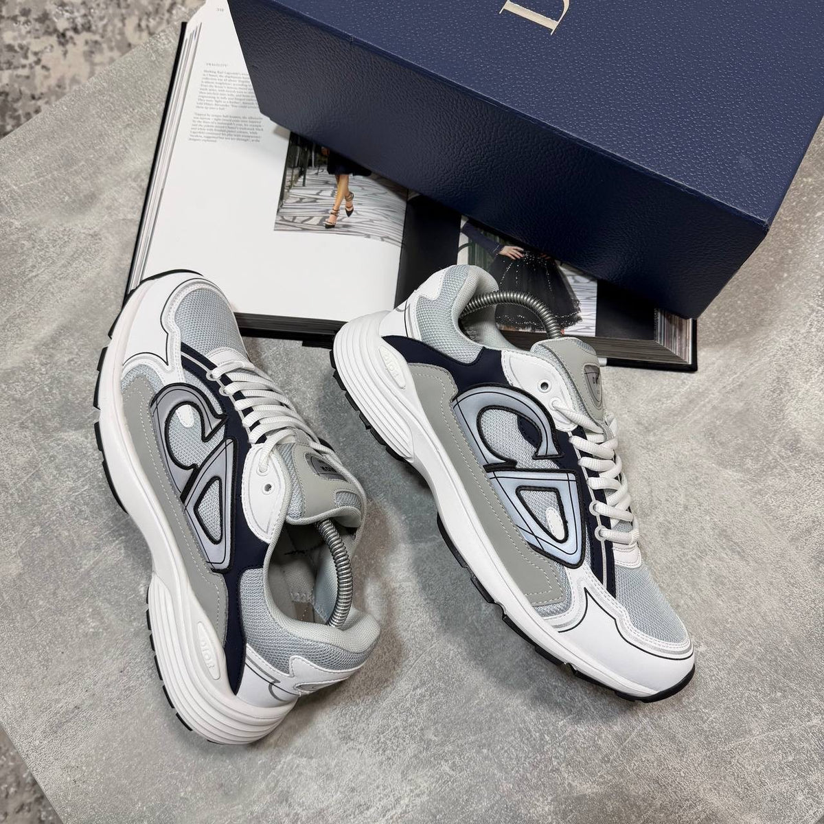 White lace-up stealth sneakers with gray and navy panels and thick rubber tread sole