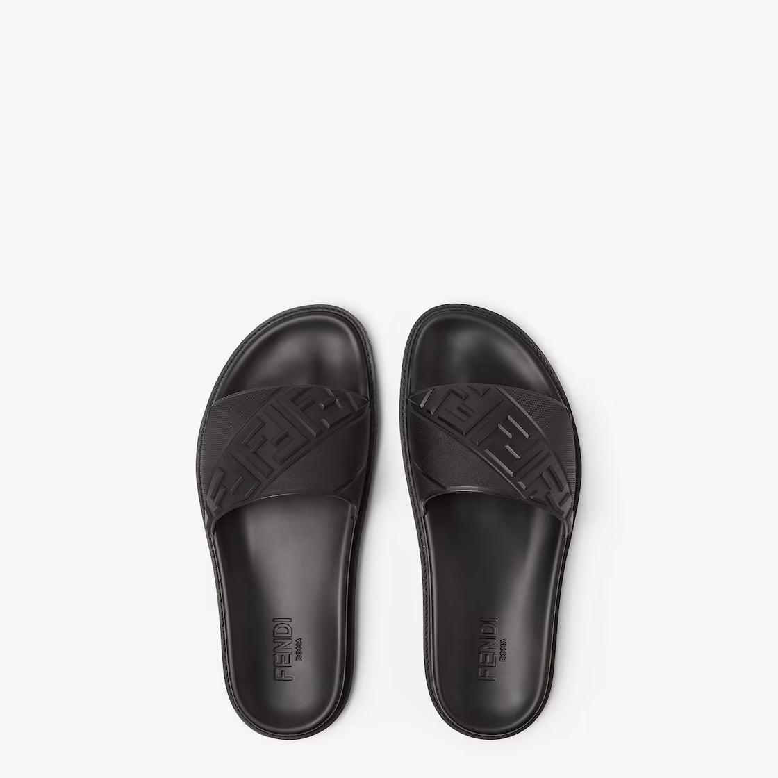 Pair of black rubber slides with embossed pattern and logo lettering on insoles
