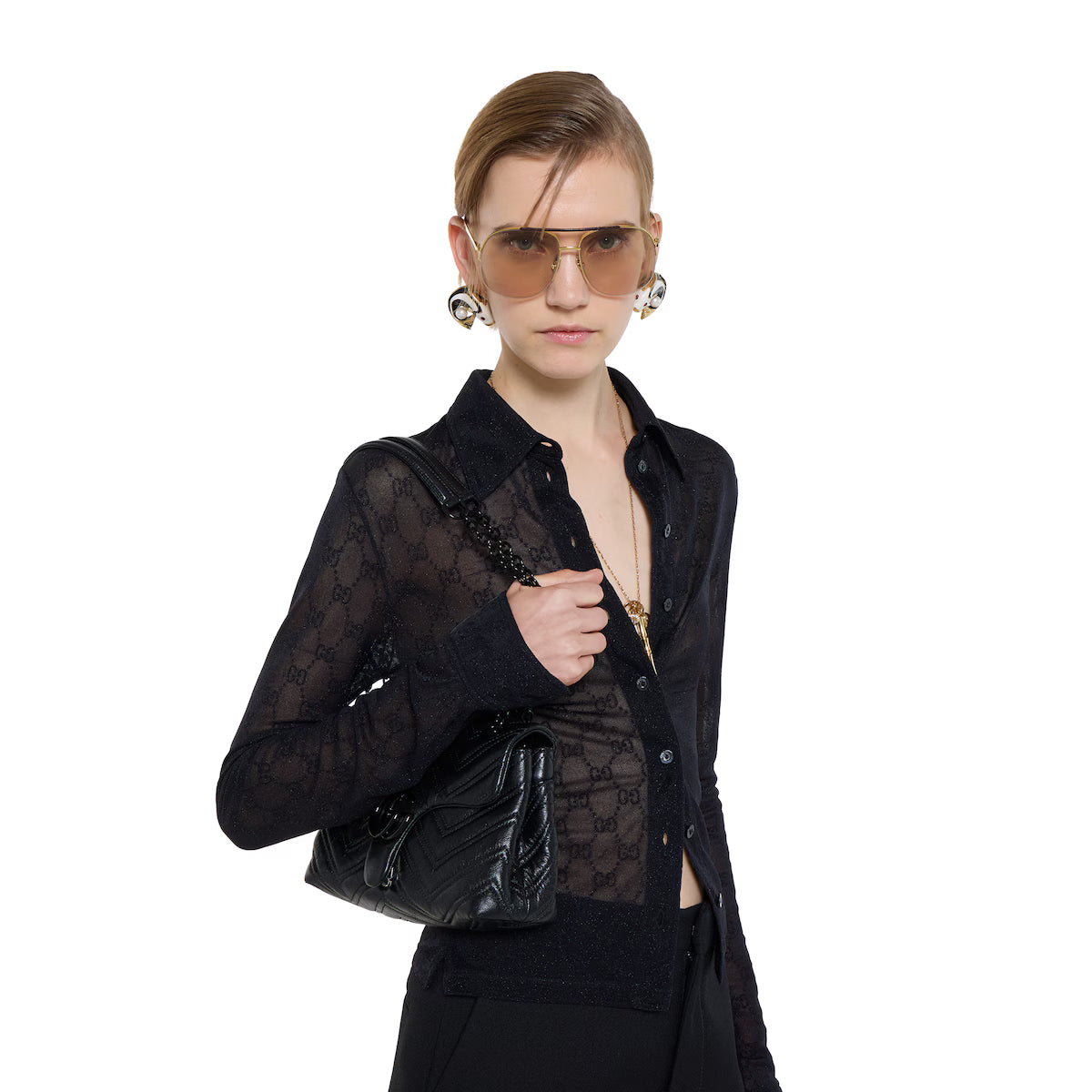 Black quilted GG Marmont small shoulder bag on model, chain strap and logo clasp