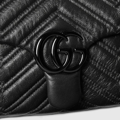 Close-up of black GG Marmont clasp on quilted leather chevron bag