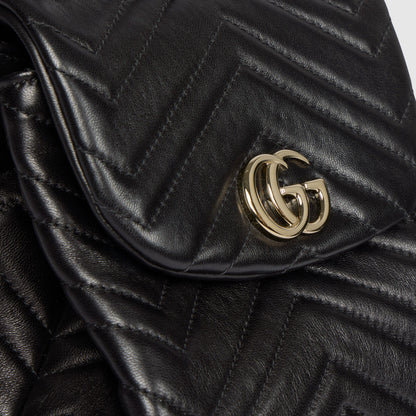 Gros plan fermoir GG doré sur mini bag noire matelassée chevrons en cuir