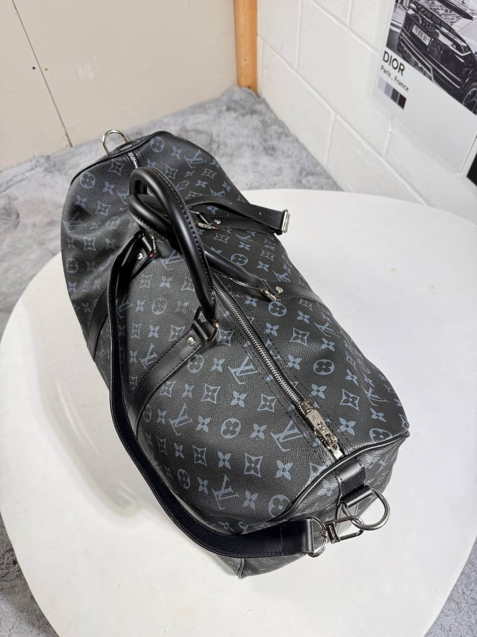 LV monogram carry bag with side buckles and metal hardware, zippered closure