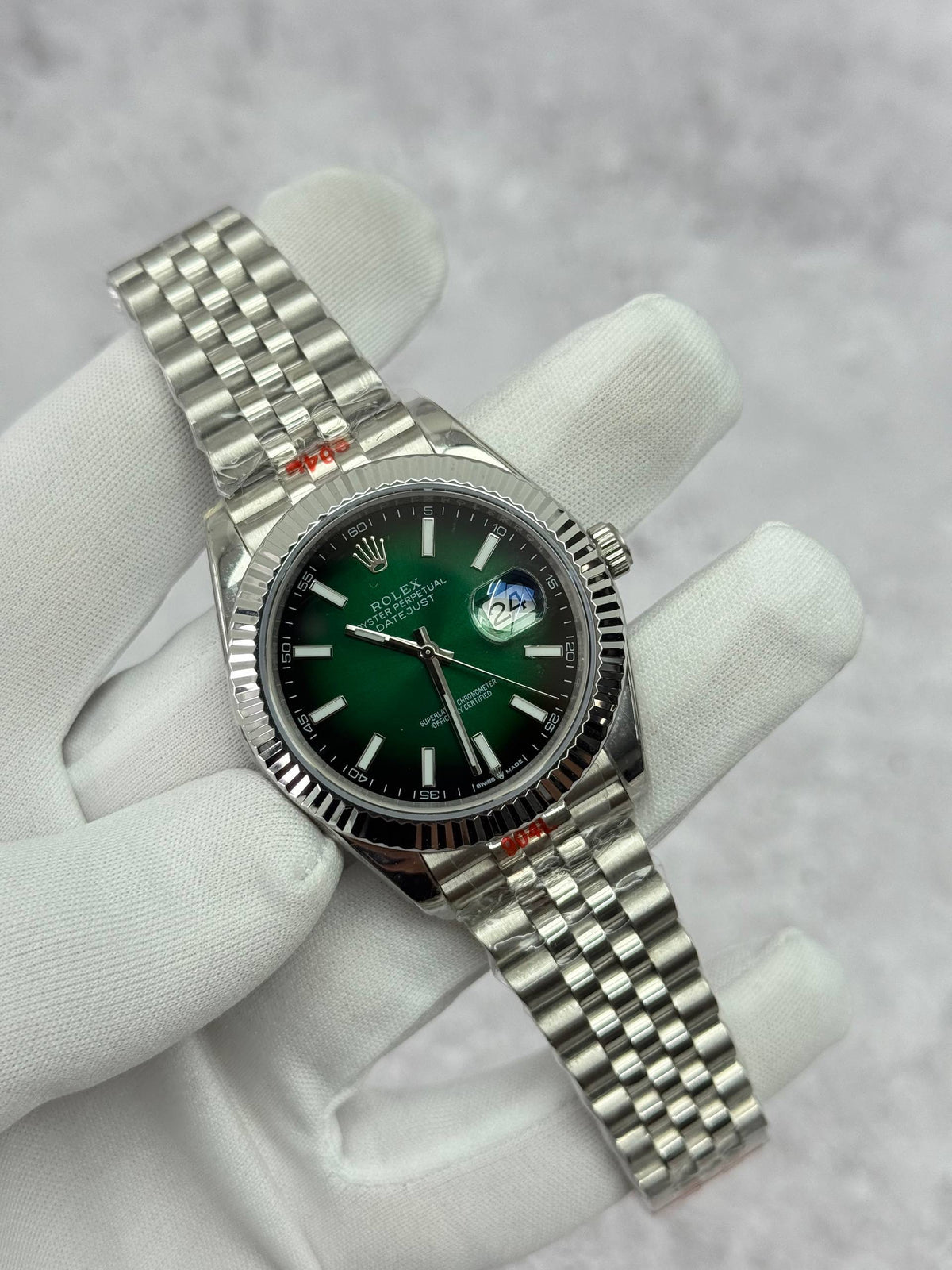 Rolex Datejust watch with green dial, stick markers, and silver link bracelet