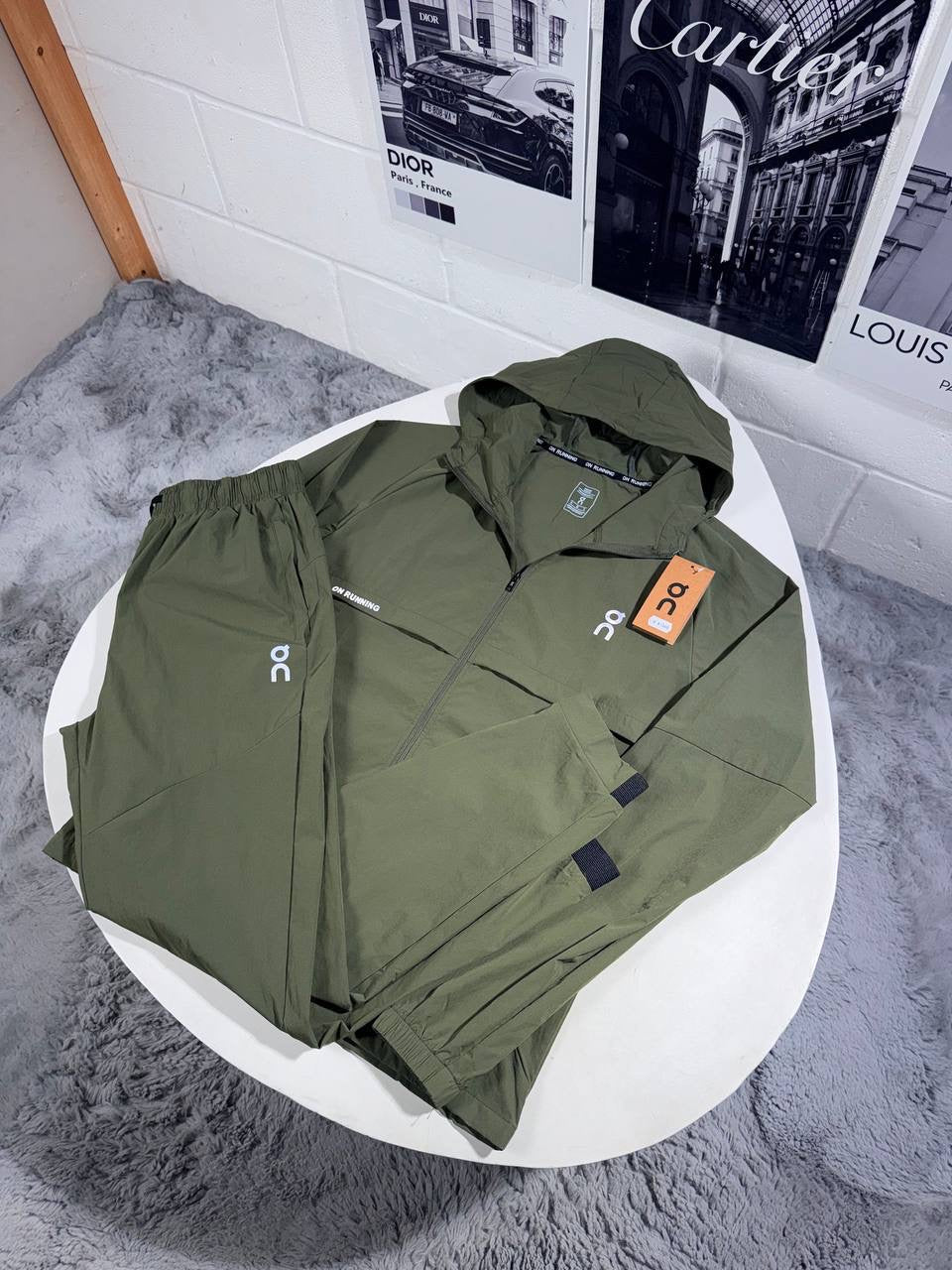 Hooded zip tracksuit jacket in dark green with logo patch and orange tag