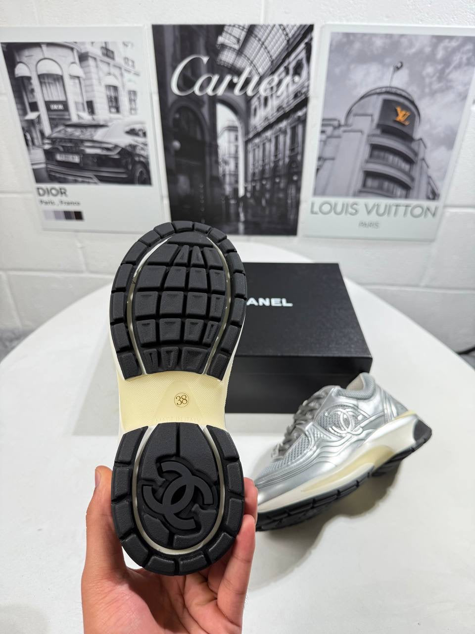Silver trainers with black rubber outsole, textured tread and heel detail