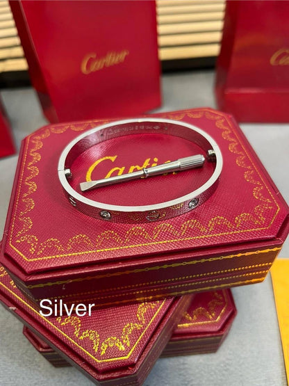 Silver love bracelet with small stud detailing on red Cartier gift box