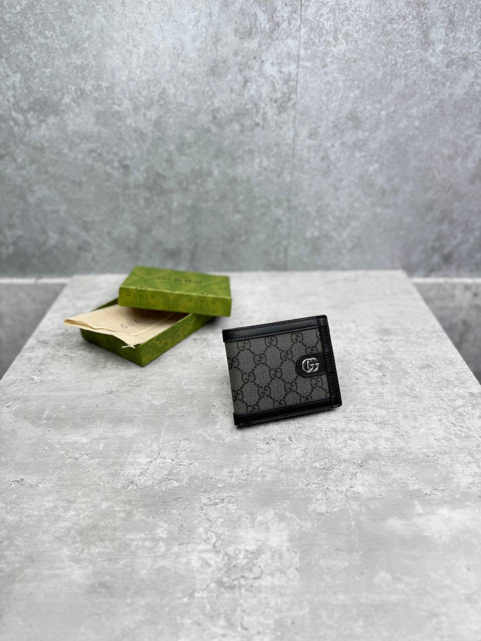 Black Gucci GG-pattern leather wallet, front view with snap button