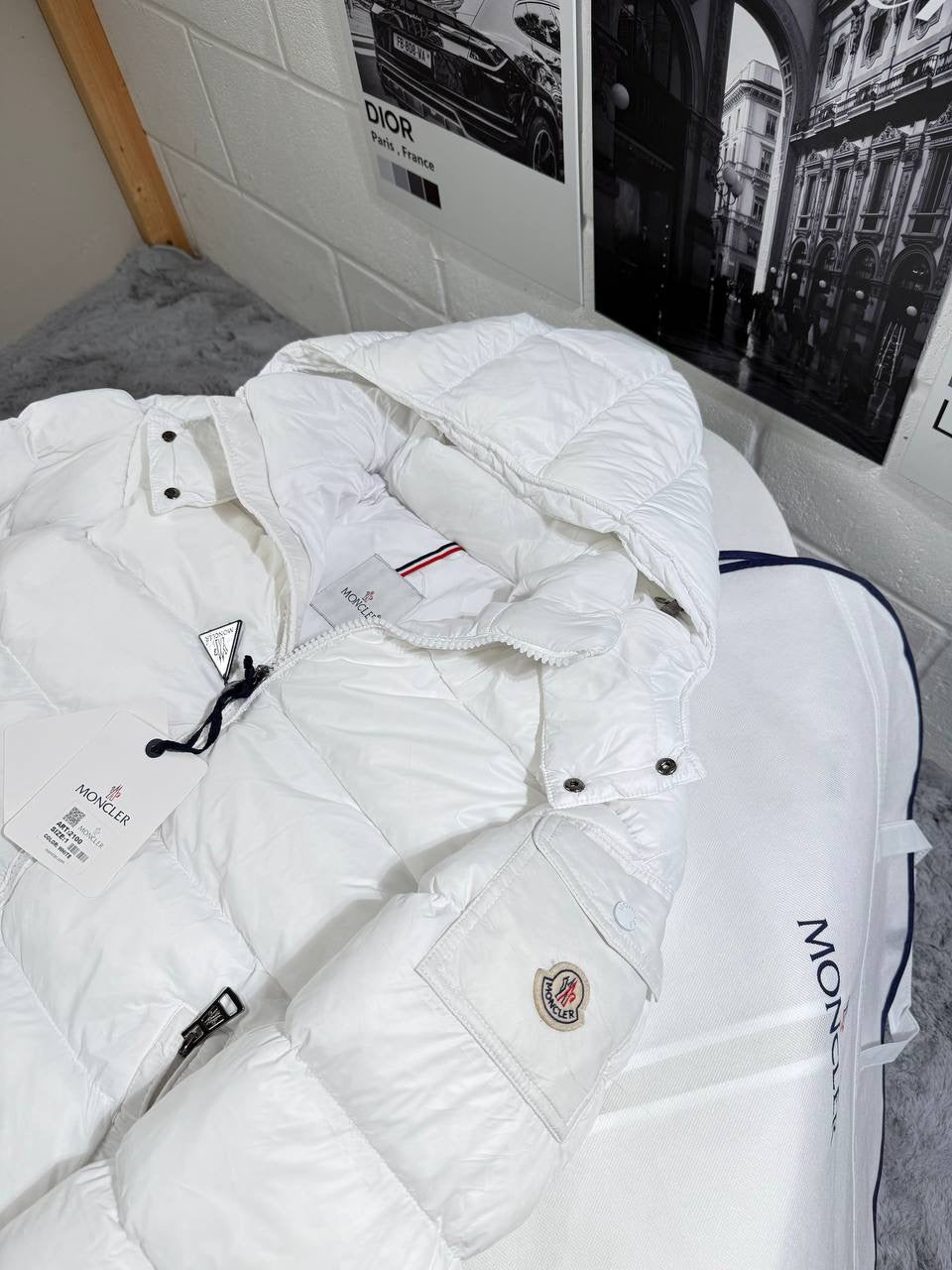 White Moncler puffer jacket with zipper front, hood drawcord, and logo patch