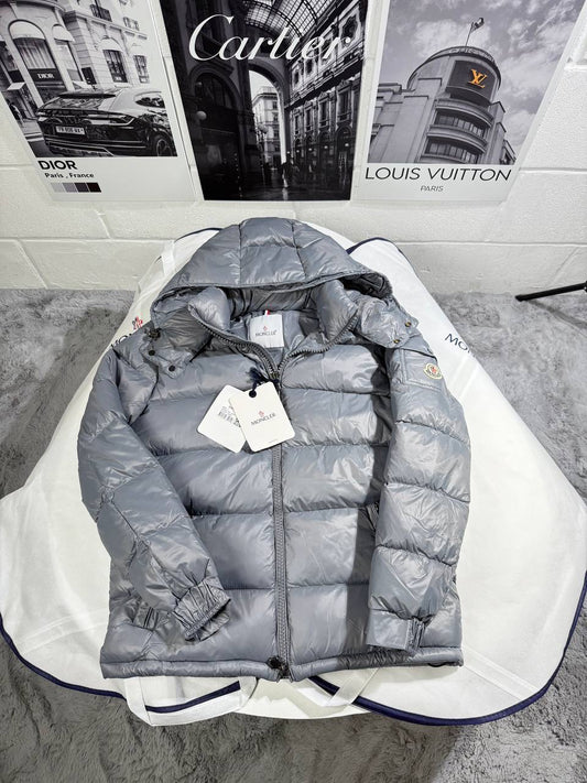 Light gray Moncler puffer jacket with hood and zipper, showing logo patch and tags