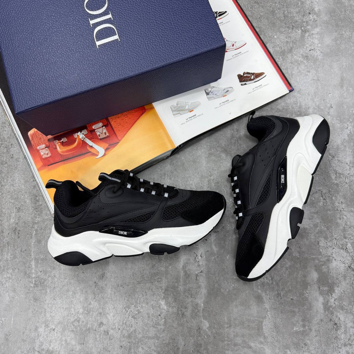 Black low-top trainers with chunky white sole, lace-up, textured upper and mesh panels