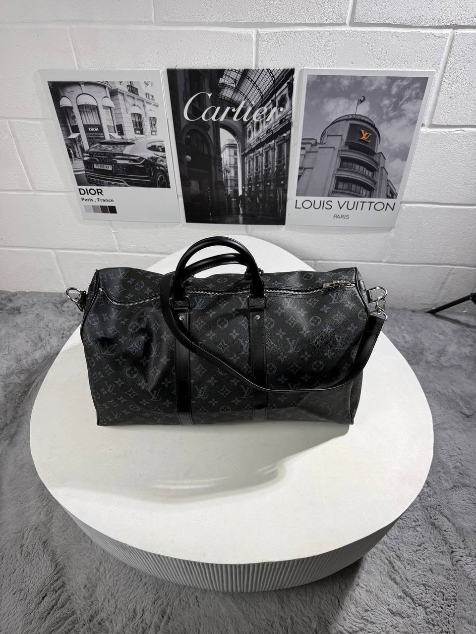 LV monogram carry bag with structured shape, metal zipper pulls, side straps