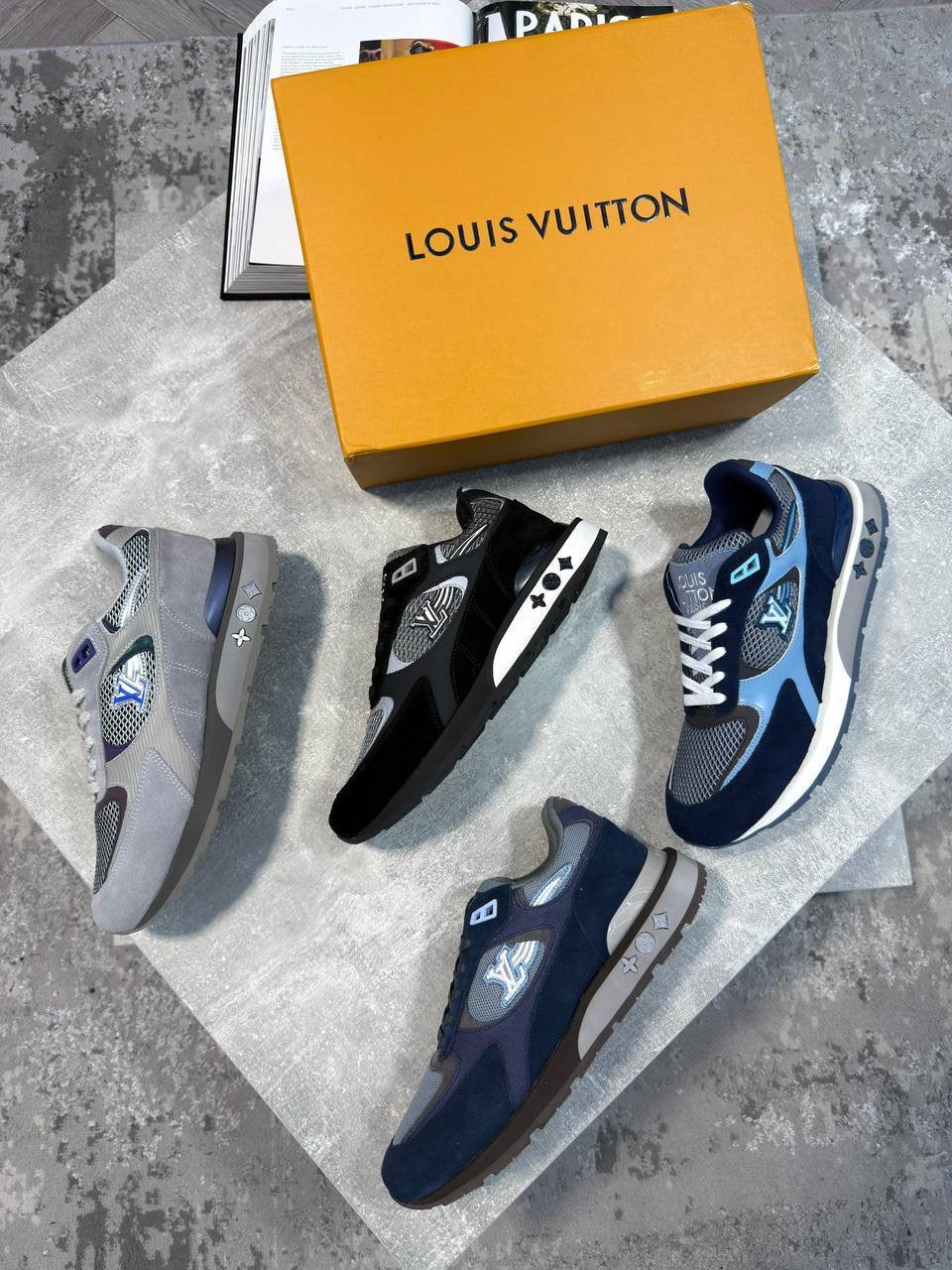 Louis Vuitton LV azure runner sneakers, set of grey, black, and navy blue pairs on display