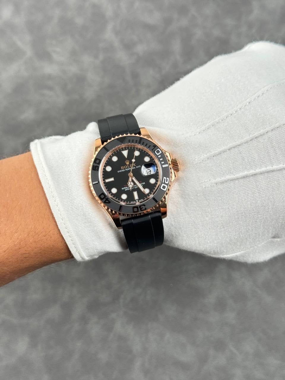 Rolex Yacht-Master style watch on wrist, black dial, rose-gold bezel, black rubber strap