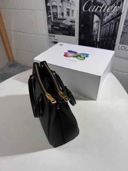 Black LV Alma BB-style bag shown from side, with gold-tone clasp and handles
