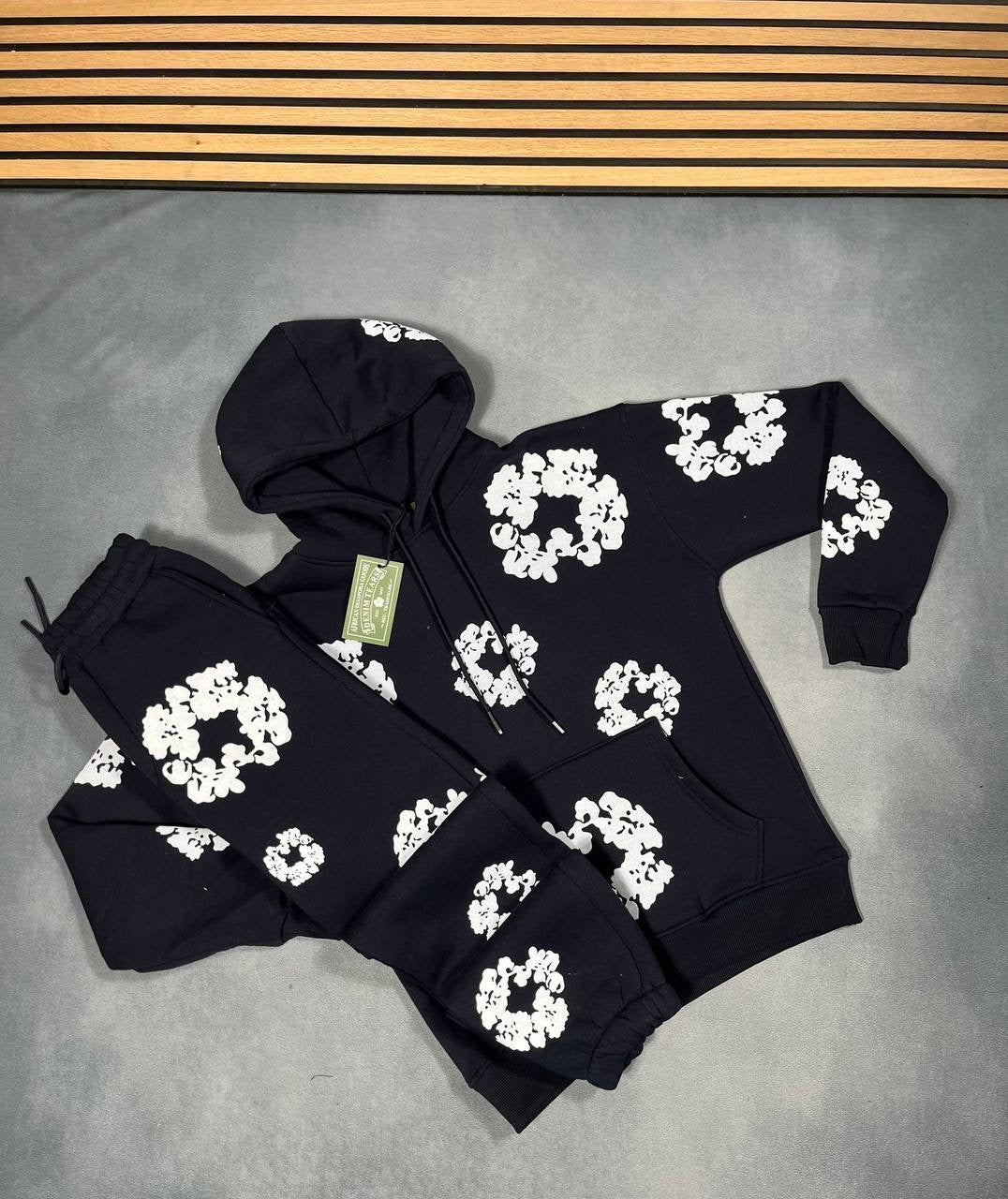 Black hoodie and jogger tracksuit set with white floral logo pattern