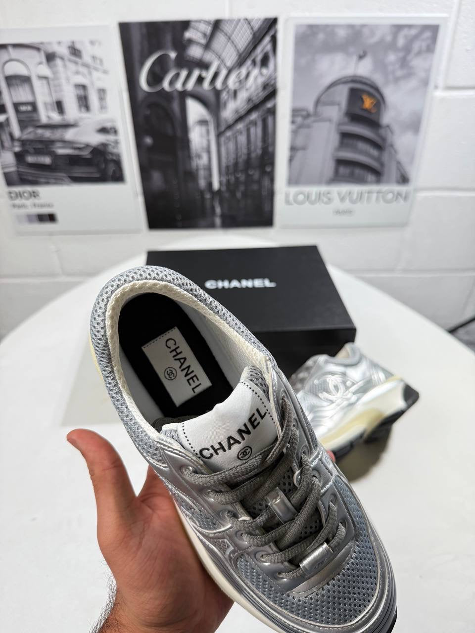 Silver trainers with lace-up front and CHANEL label at the collar