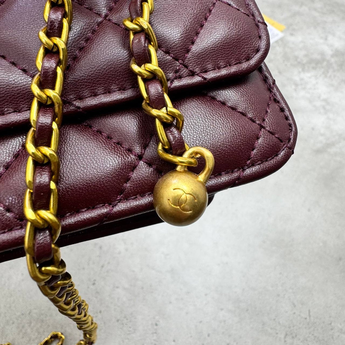 Burgundy quilted leather flap bag with gold-tone chain and CC charm