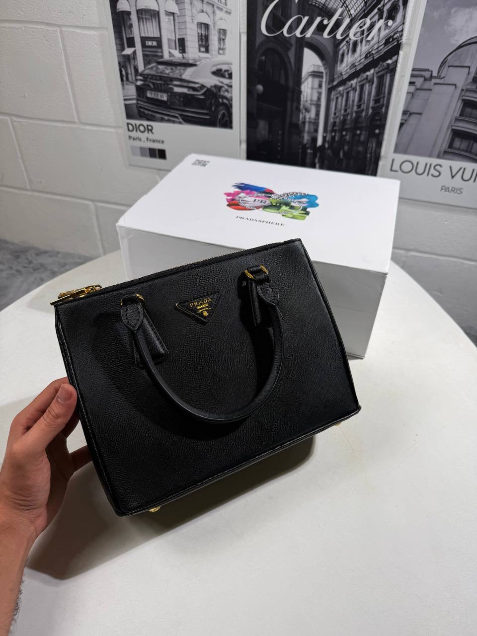 Black LV Alma BB-style crossbody bag with structured body and gold-tone hardware