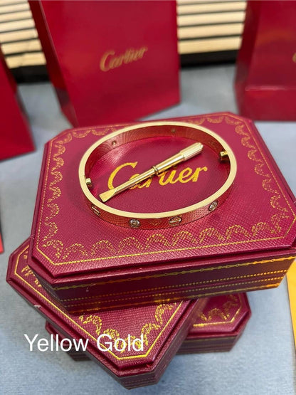 Yellow gold love bracelet with Cartier bar detail on red Cartier gift box
