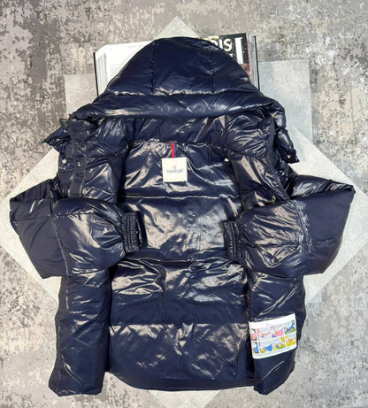 Navy puffer jacket with hood, front zipper, and red trim accents