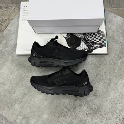 Black lace-up training shoes with textured upper and thick rubber tread sole