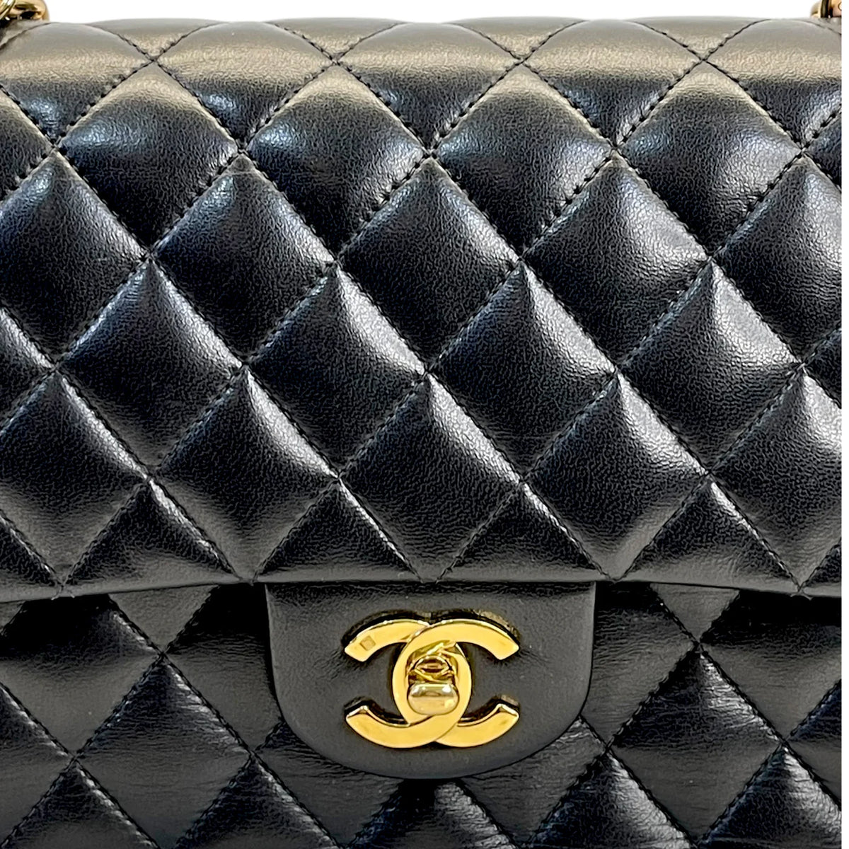 Gold Chanel-style logo on dark quilted leather classic double flap bag