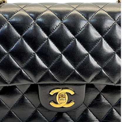 Gold Chanel-style logo on dark quilted leather classic double flap bag
