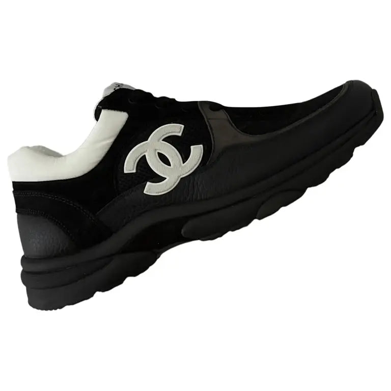 Black leather low trainers with large white CC logo on the side and cushioned collar