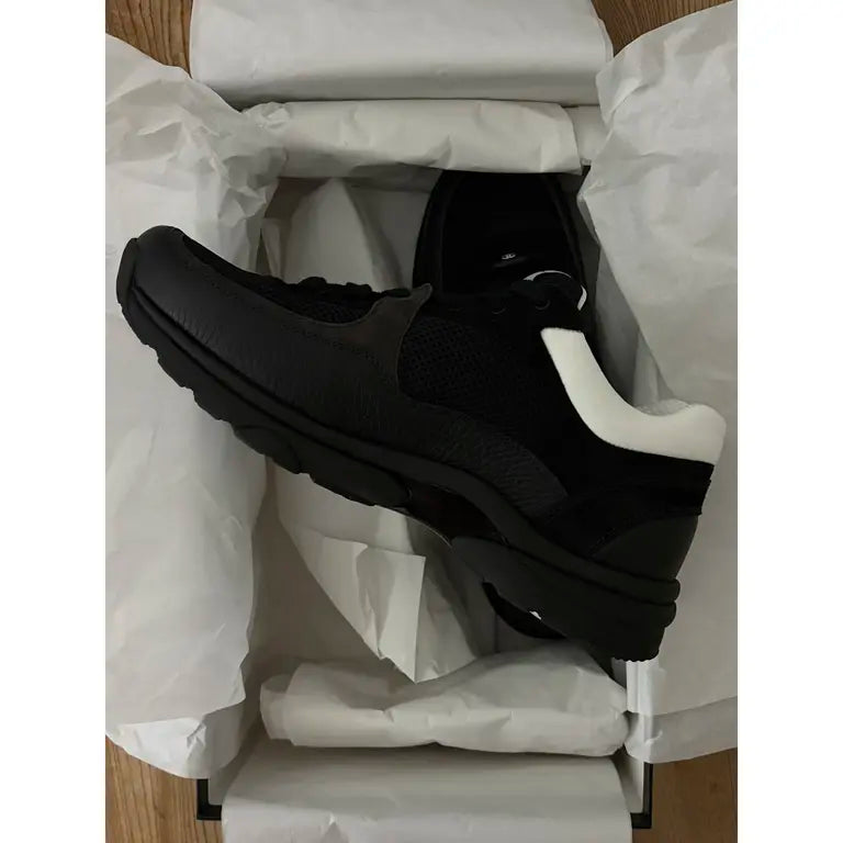 Black leather low trainers with white rubber sole and textured side panels