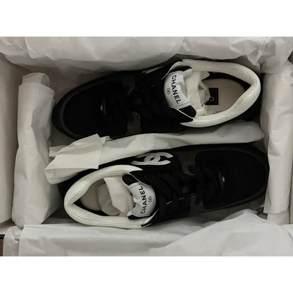 Black and white leather low trainers in box, CHANEL logo on tongue label