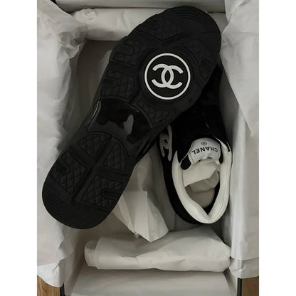 Black leather low trainers with circular logo outsole and textured tread pattern
