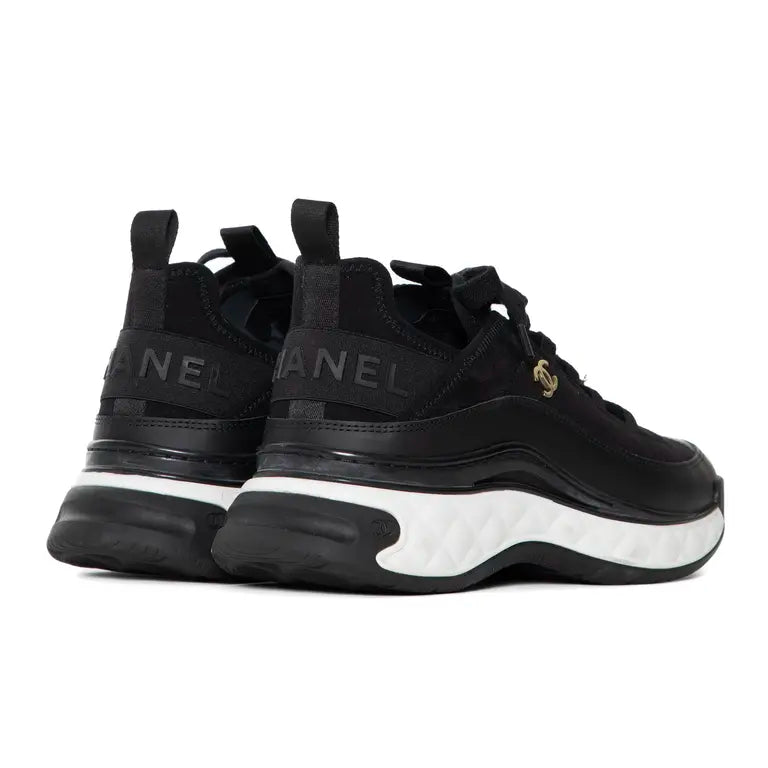 Schwarzer Sneaker mit Schriftzug „CHANEL“ am Fersenriemen und profilierter Sohle