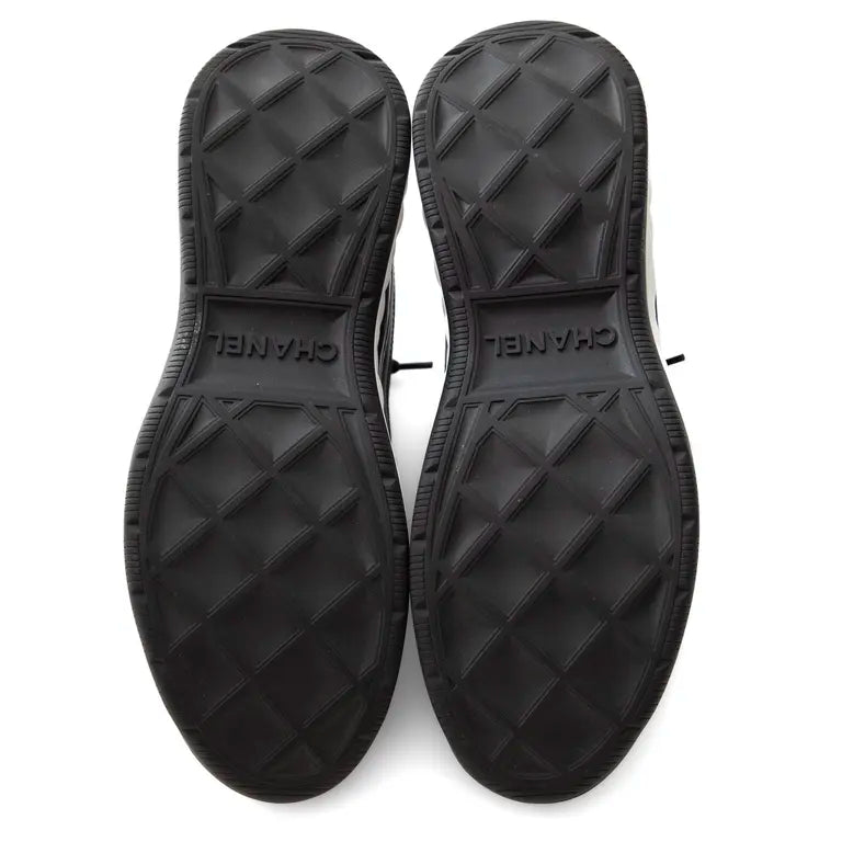 Außensohlen der schwarzen Sneaker mit Profil und Prägung „CHANEL“