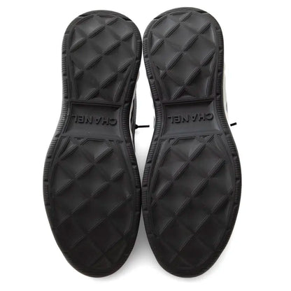 Außensohlen der schwarzen Sneaker mit Profil und Prägung „CHANEL“