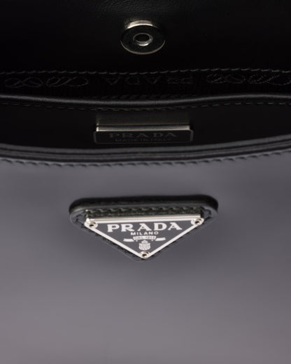 Prada triangle logo on black leather bag, metal clasp and stitching