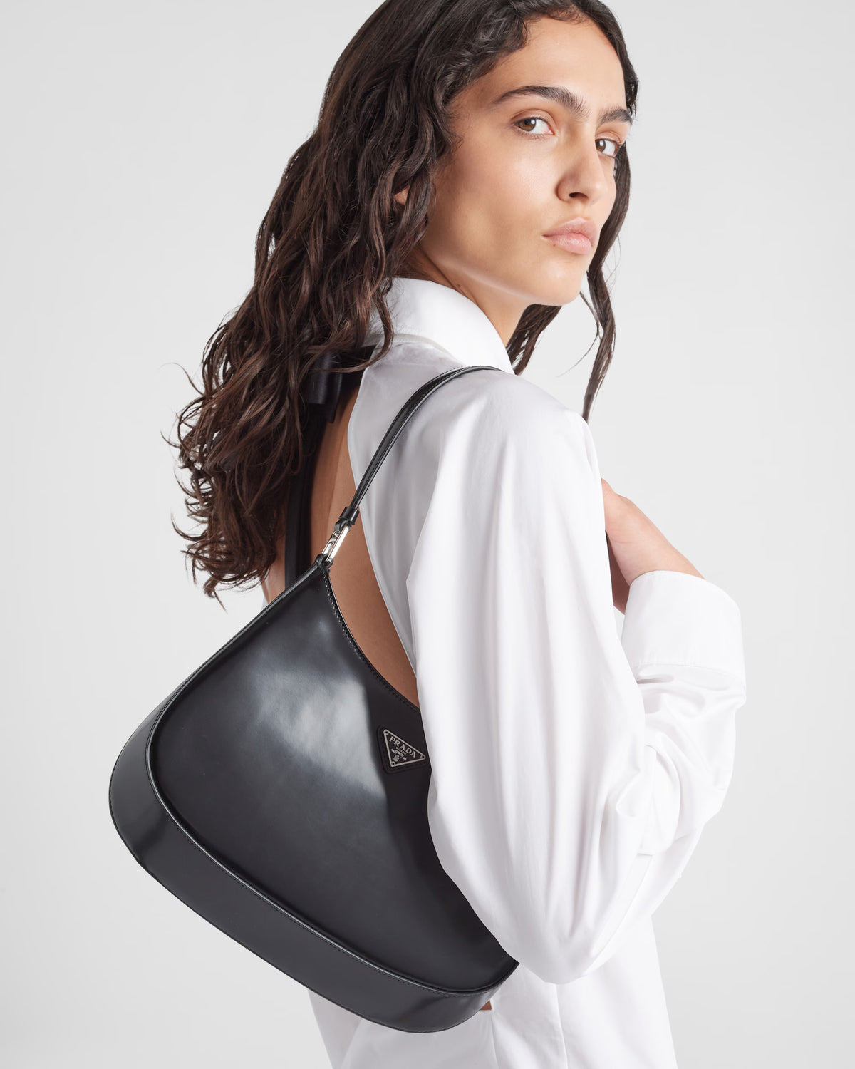 Prada Cleo shoulder bag on model, black curved bag with top handle