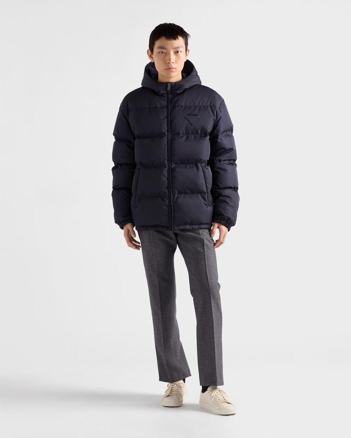Hooded down jacket in dark navy, full-length front zip and side pocket openings visible.