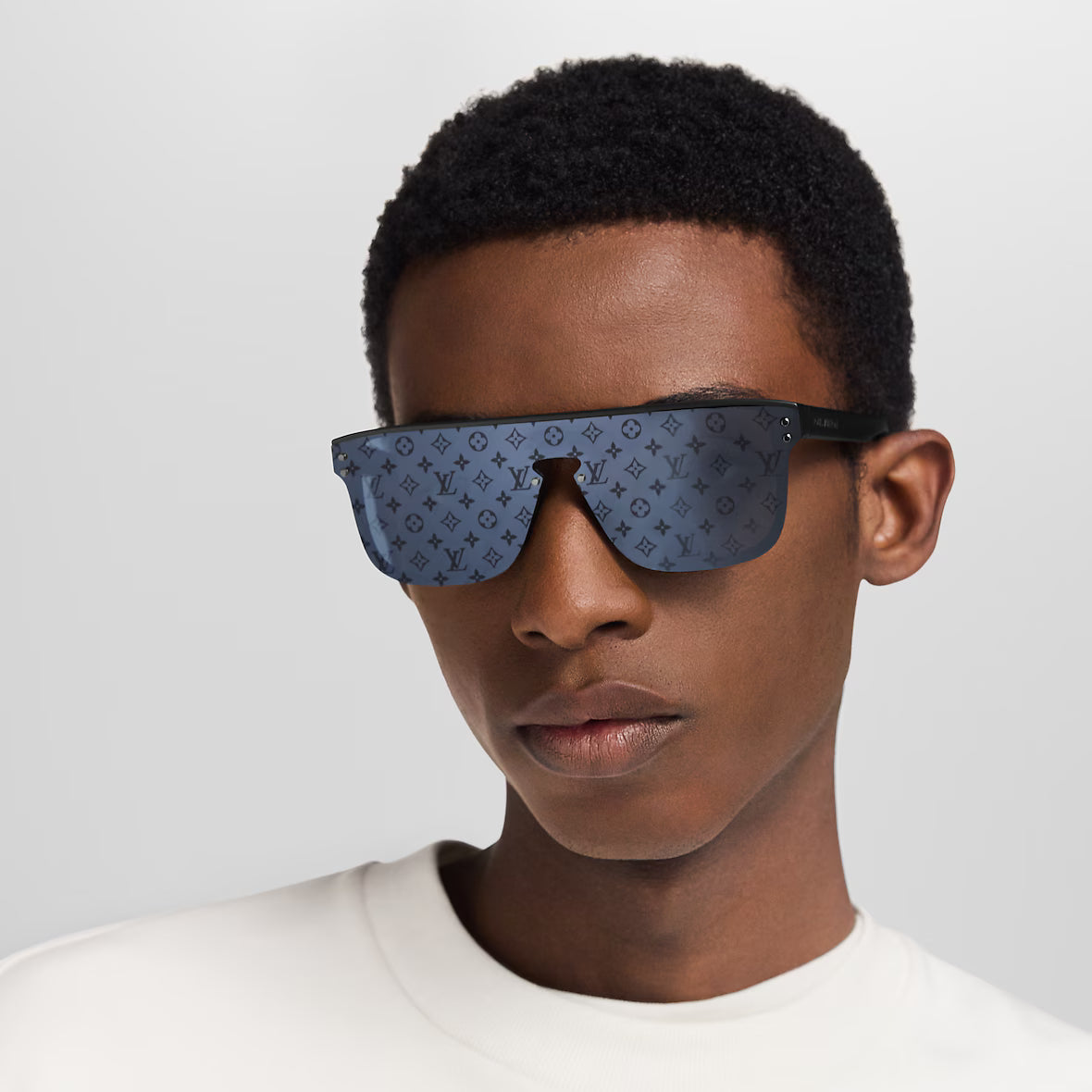 Waimea sunglasses on model: dark blue patterned lenses with black arms