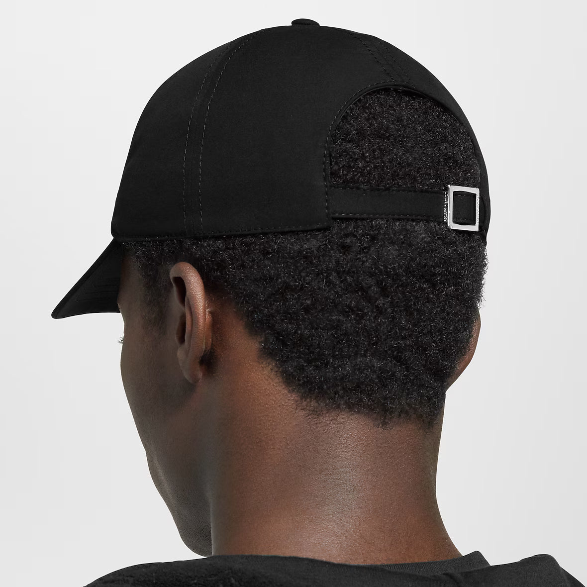 Black cap side view with adjustable strap buckle detail