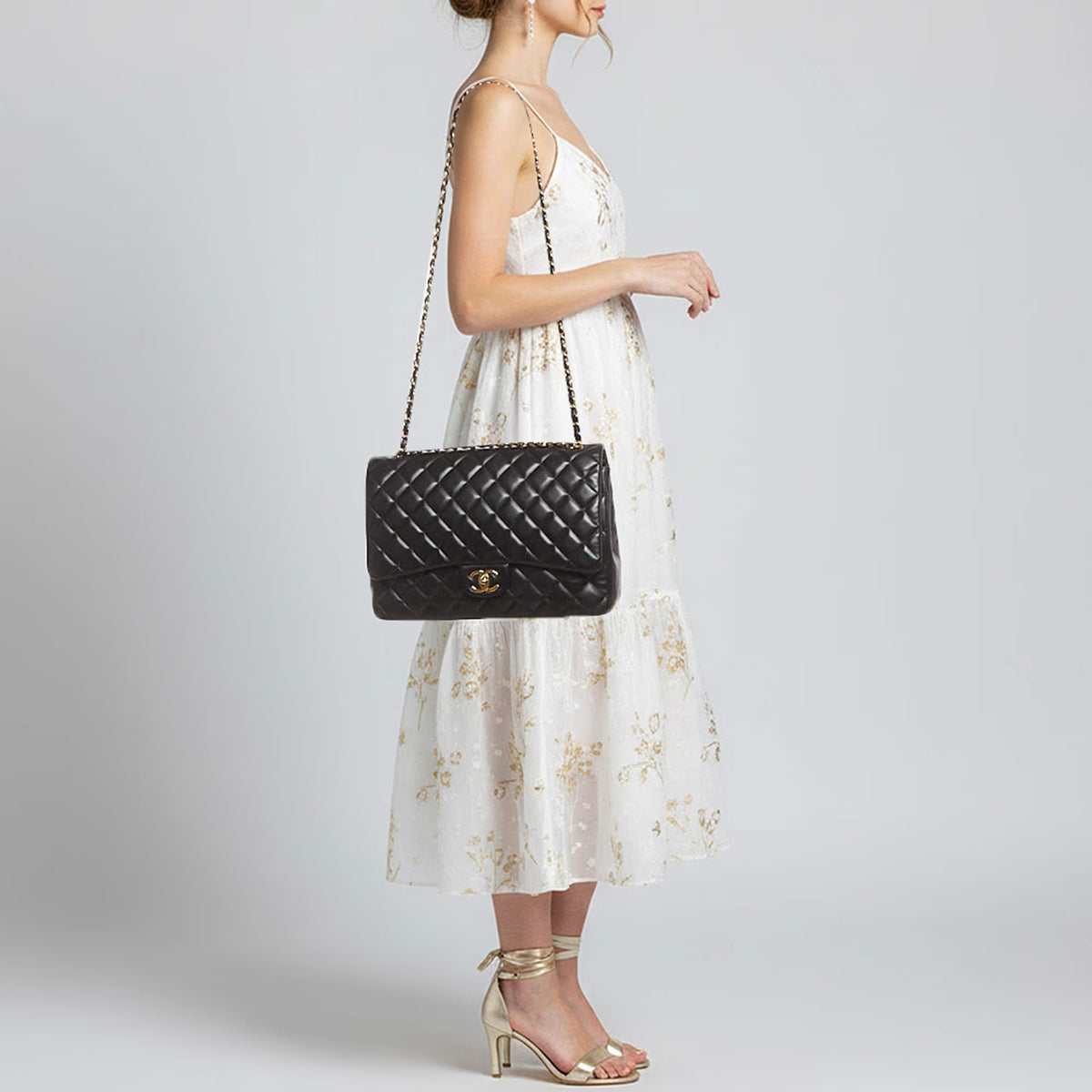 Maxi Classic Flap crossbody bag worn on model; black quilted front flap and chain