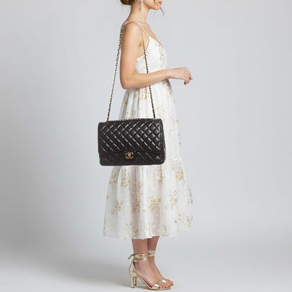 Maxi Classic Flap crossbody bag worn on model; black quilted front flap and chain